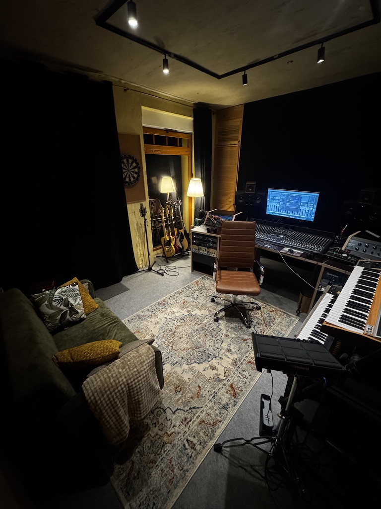 Regieraum mit Couch, Mischpult und Synthesizern im MJM Studio